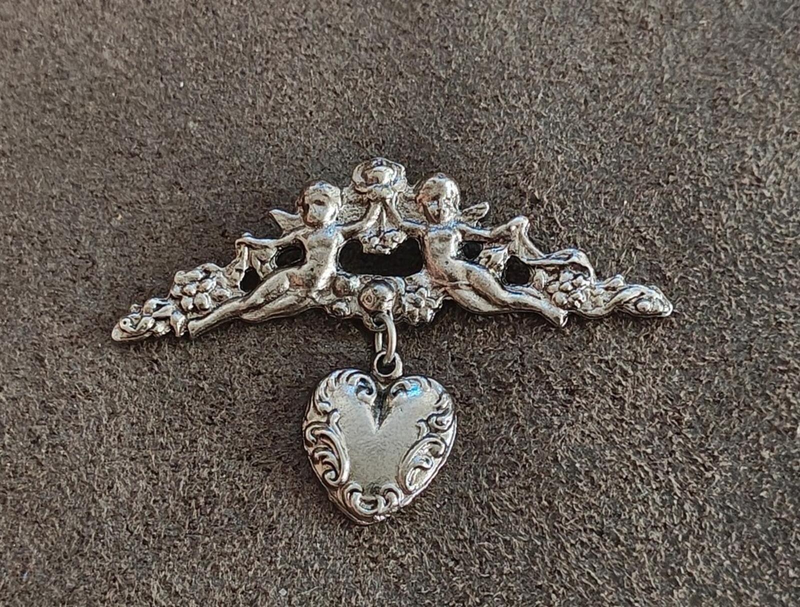 1980s Silver Tone Renaissance Style Cherub Brooch With Dangling Heart Charm