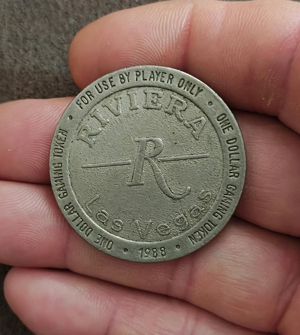 Silver one-dollar gaming token with Riviera logo and one dollar ring text