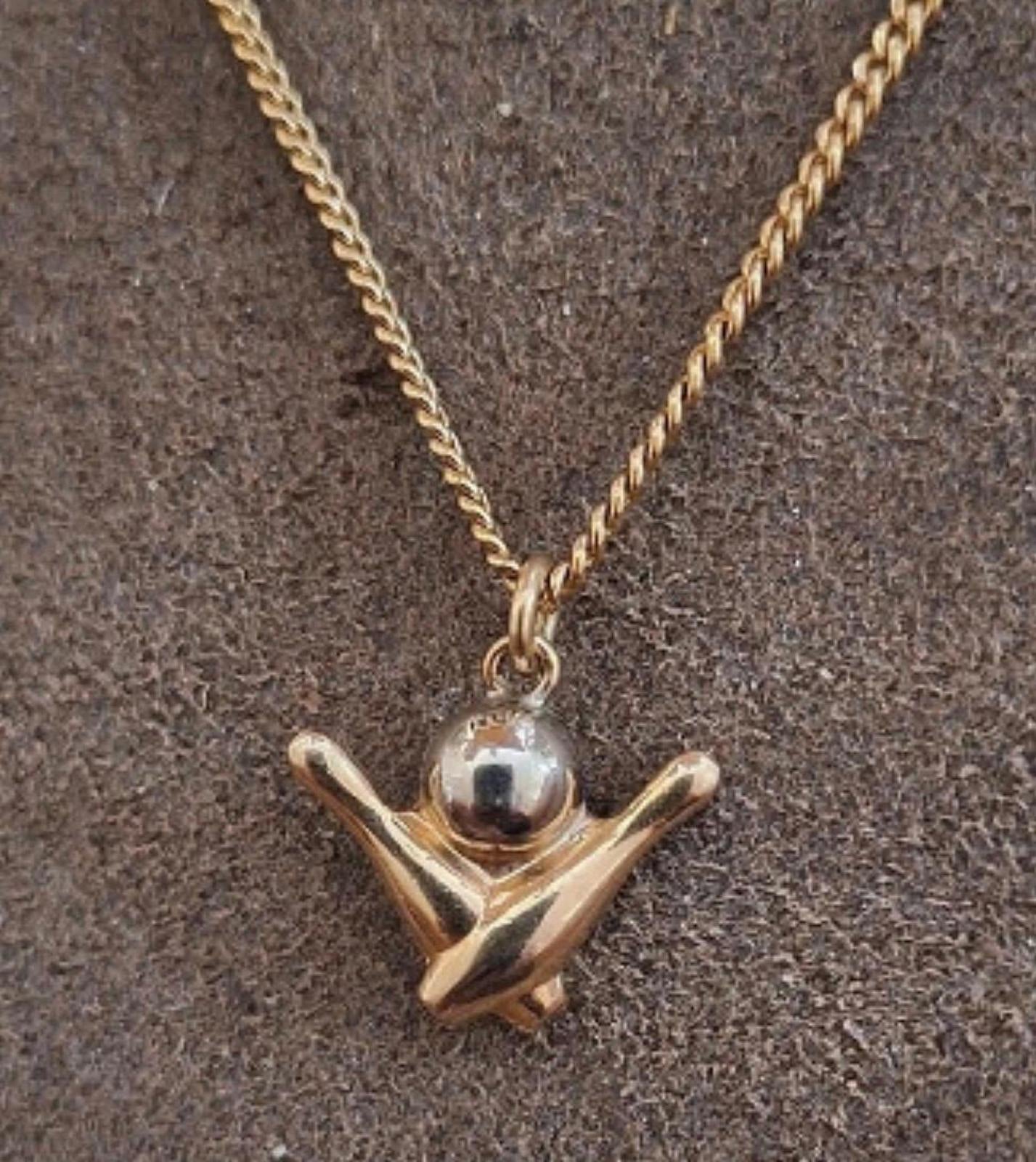 Gold-tone chain with bowling pin charm pendant, secured by a small clasp ring.