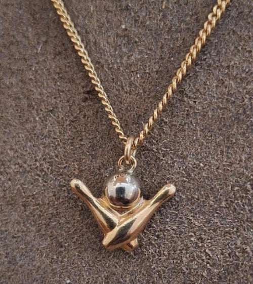 Gold-tone chain with bowling pin charm pendant, secured by a small clasp ring.