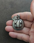 Silver-tone jack-o'-lantern charm pendant with carved grin and loop bail
