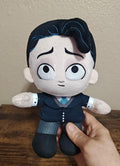 Black plush doll with pale face, stitched smile, blue-gray striped pants