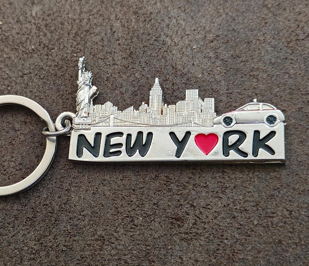 Silver New York keychain close-up with engraved skyline, Statue landmark, red heart "NEW YORK"