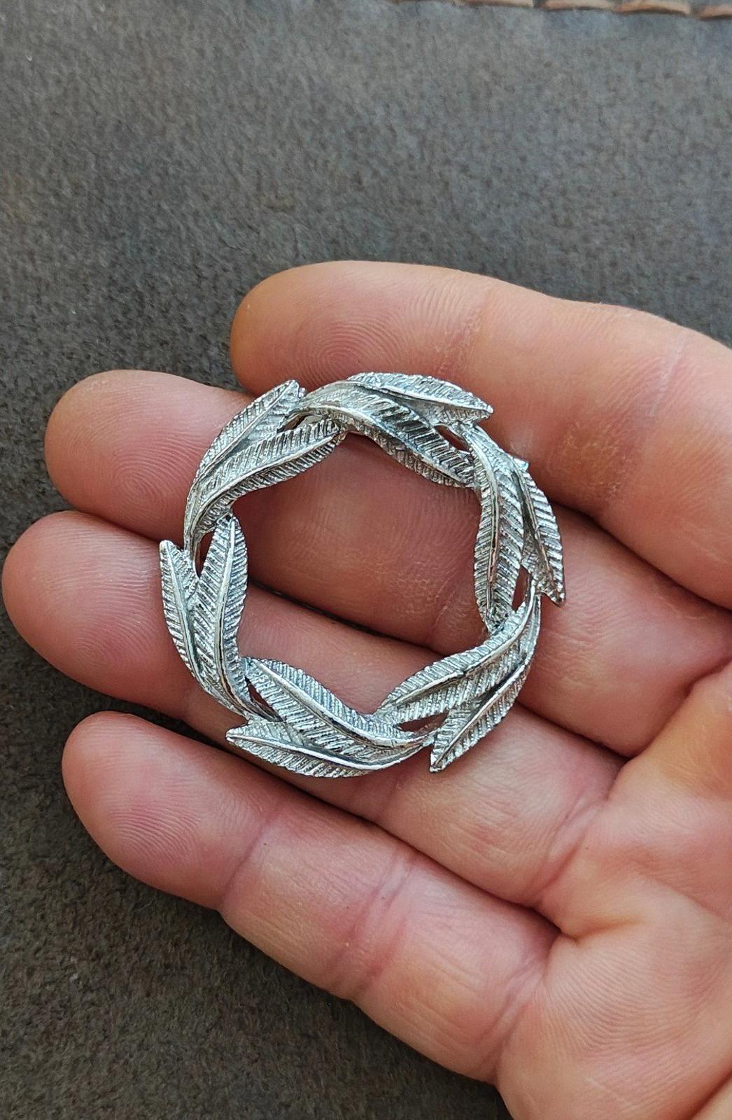 Silver-tone leaf circle pin brooch, textured ridged leaf design close-up