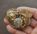 Gold tone celestial charm brooch with moon and sun rhinestone details and beaded edge.