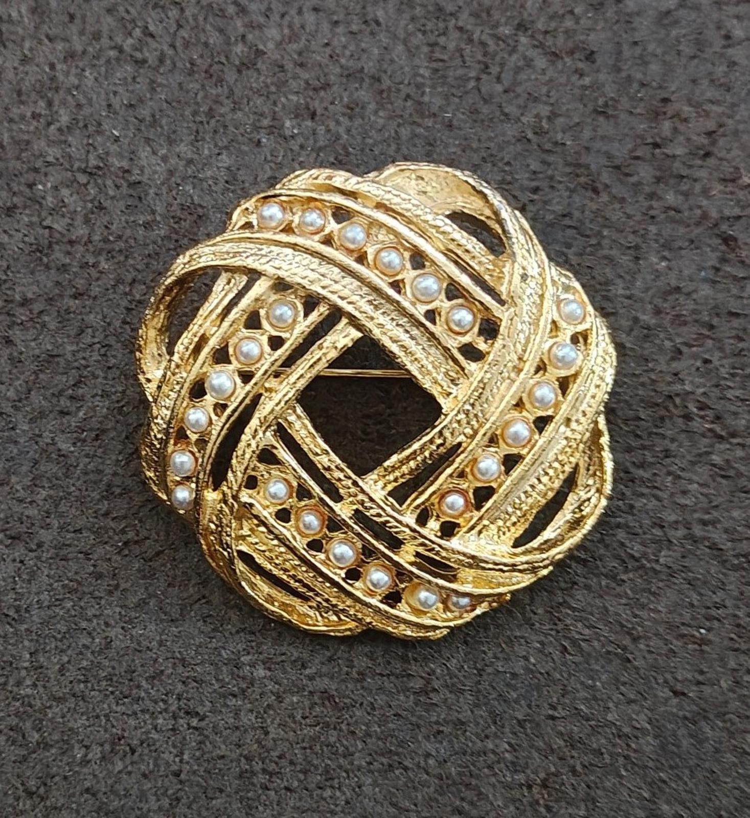 Gold-tone brooch with faux pearl border and swirling filigree crosshatch design