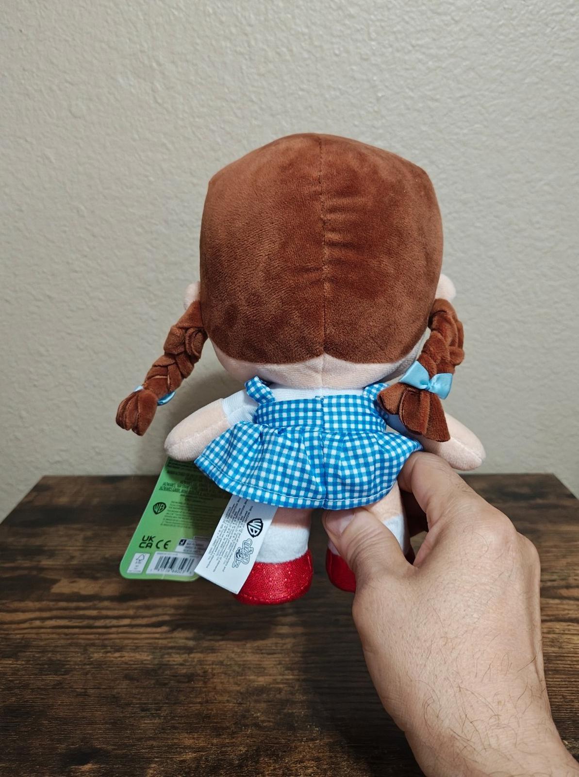 Dorothy-style plush doll back view, blue gingham dress, red shoes, care label attached