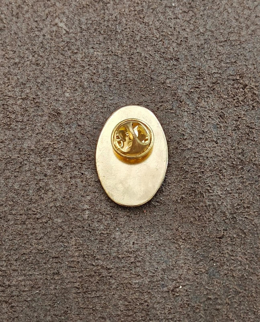 Oval gold-tone pin back with metal post and safety clasp