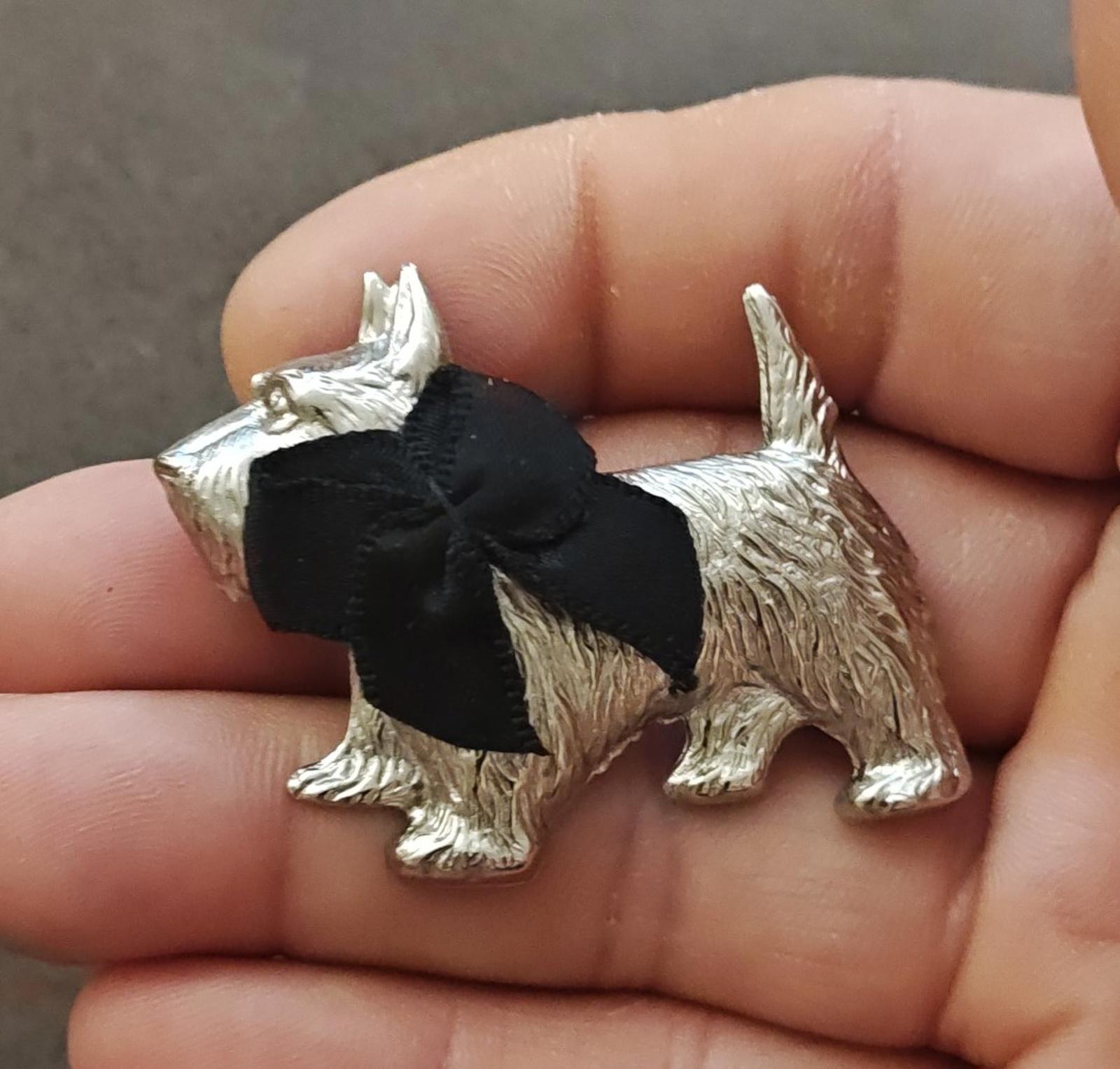 Silver-tone Scottish terrier brooch with black bow and glossy sculpted texture