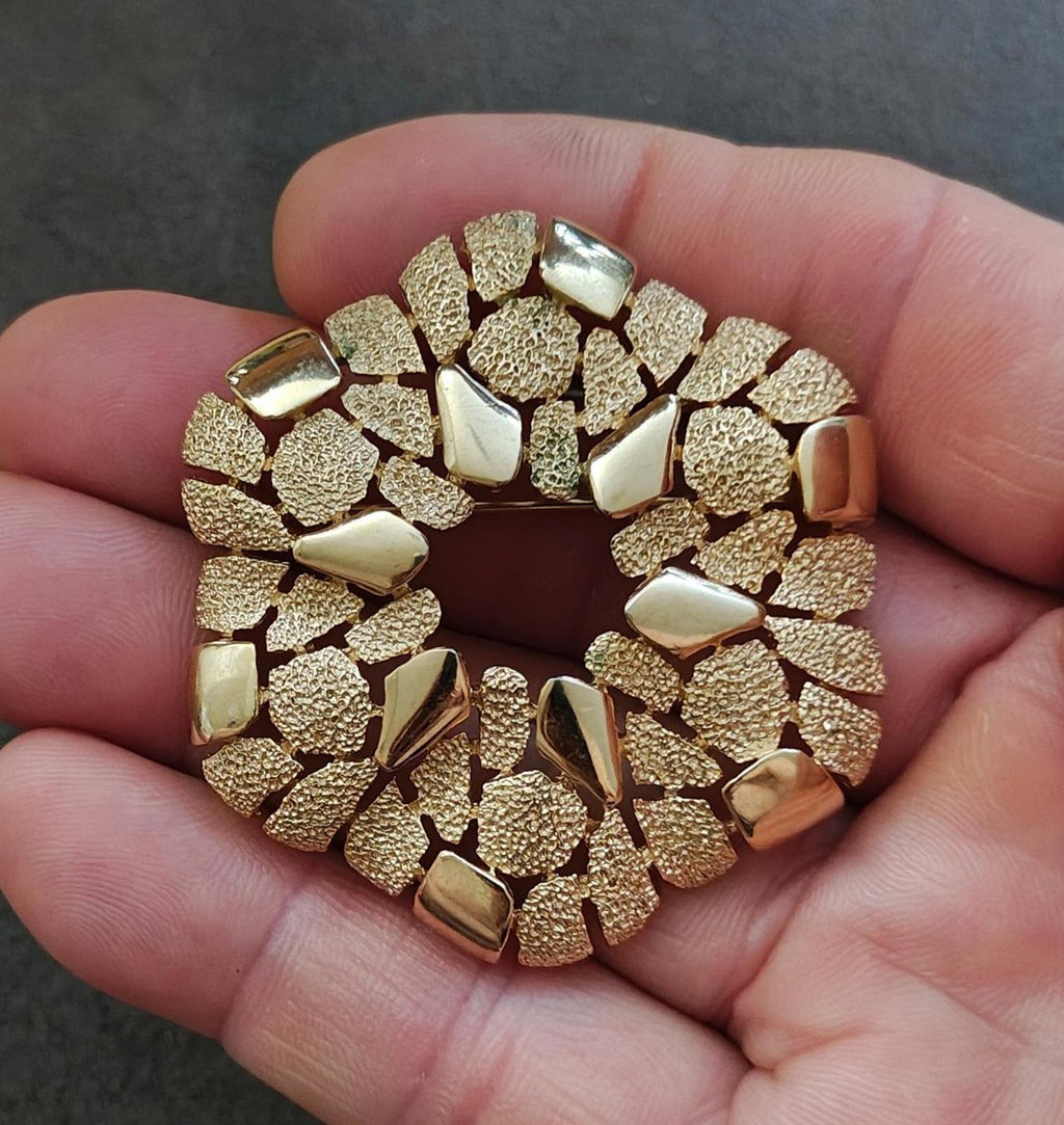 Gold-tone textured wreath brooch with raised cobblestone-like segments