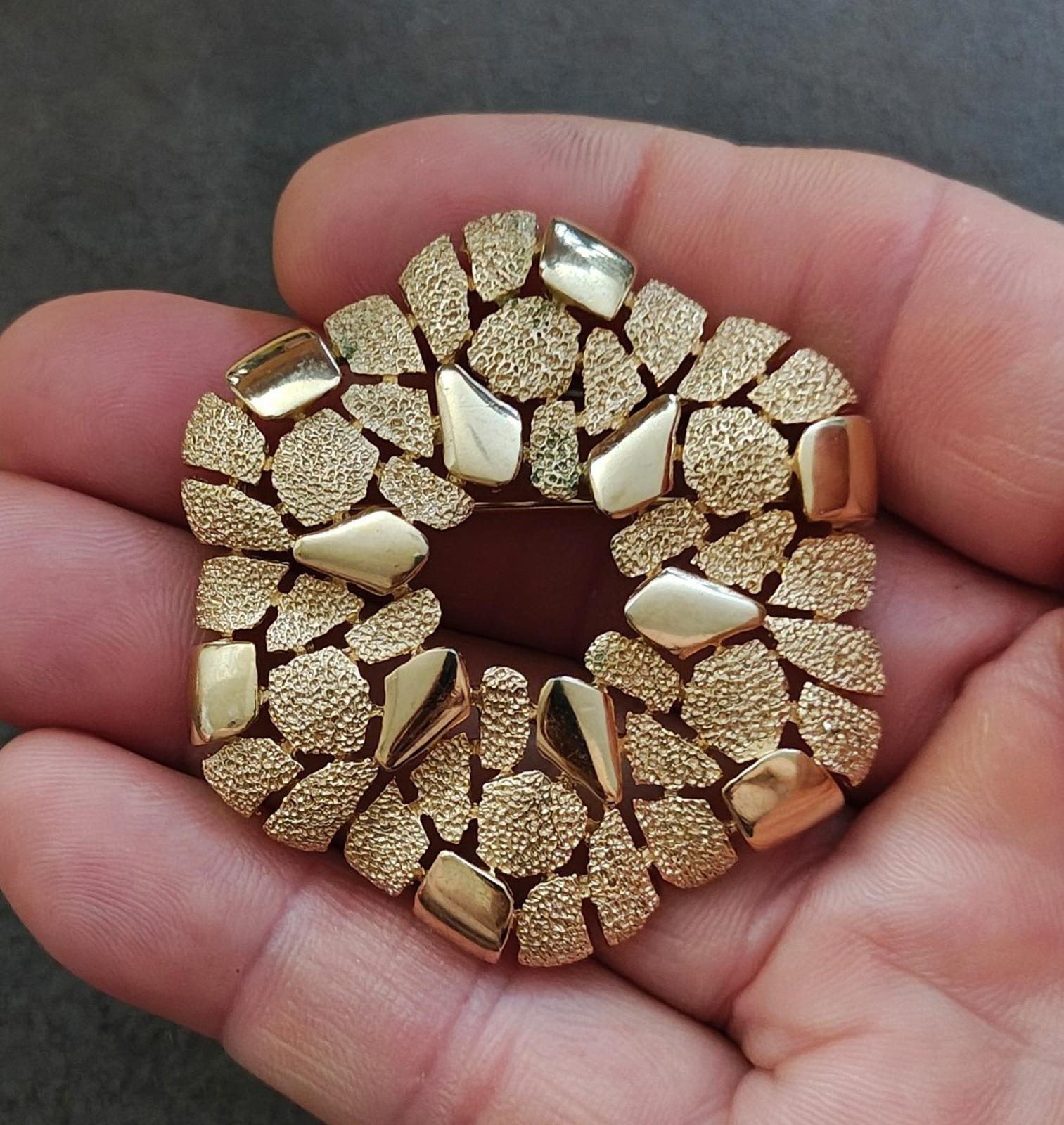 Gold-tone textured wreath brooch with raised cobblestone-like segments