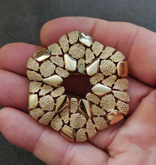 Gold-tone textured wreath brooch with raised cobblestone-like segments