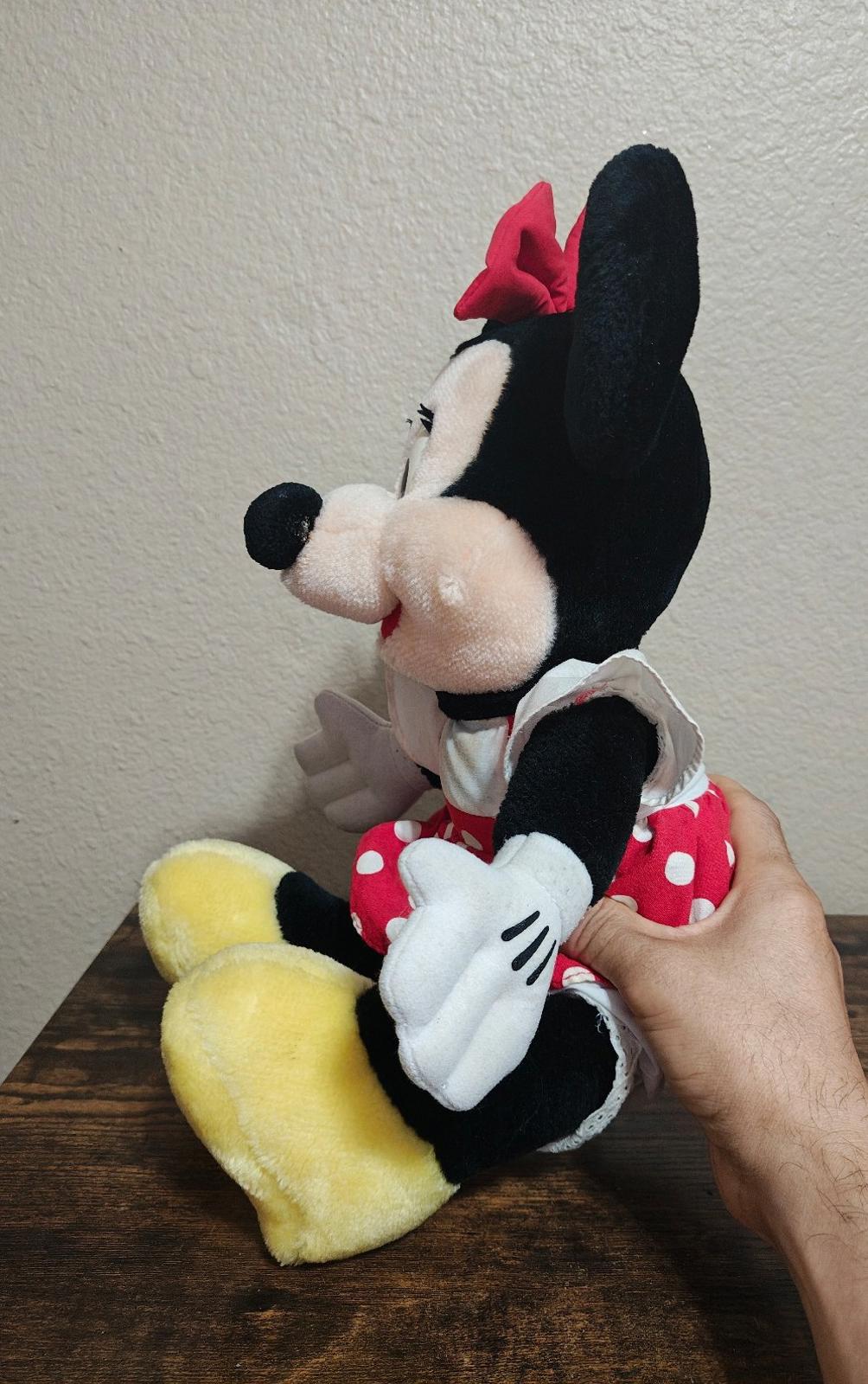Minnie Mouse plush in red polka-dot dress, facing left, arms by side, yellow feet