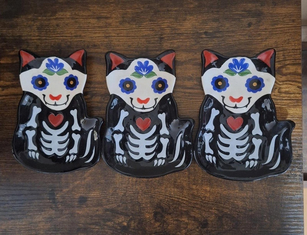 Three black 3D cat sugar skull trinket plates with blue flowers and red heart centers