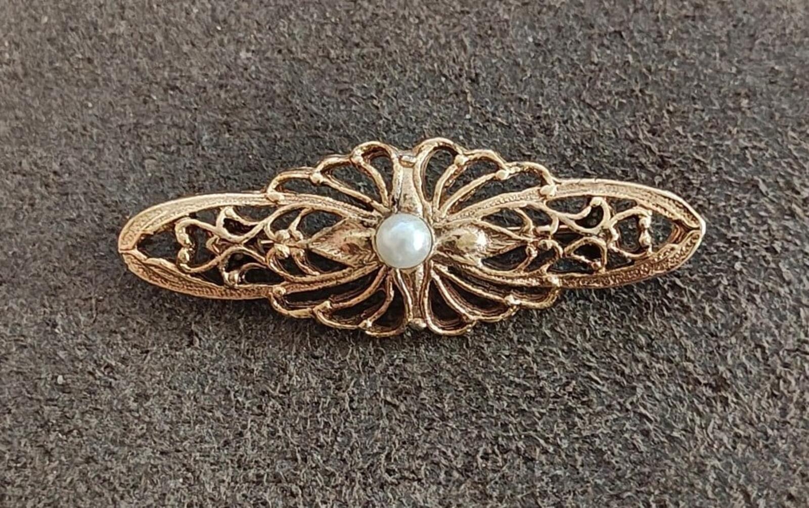 Gold-tone Victorian-style bar brooch with faux pearl center and filigree wings