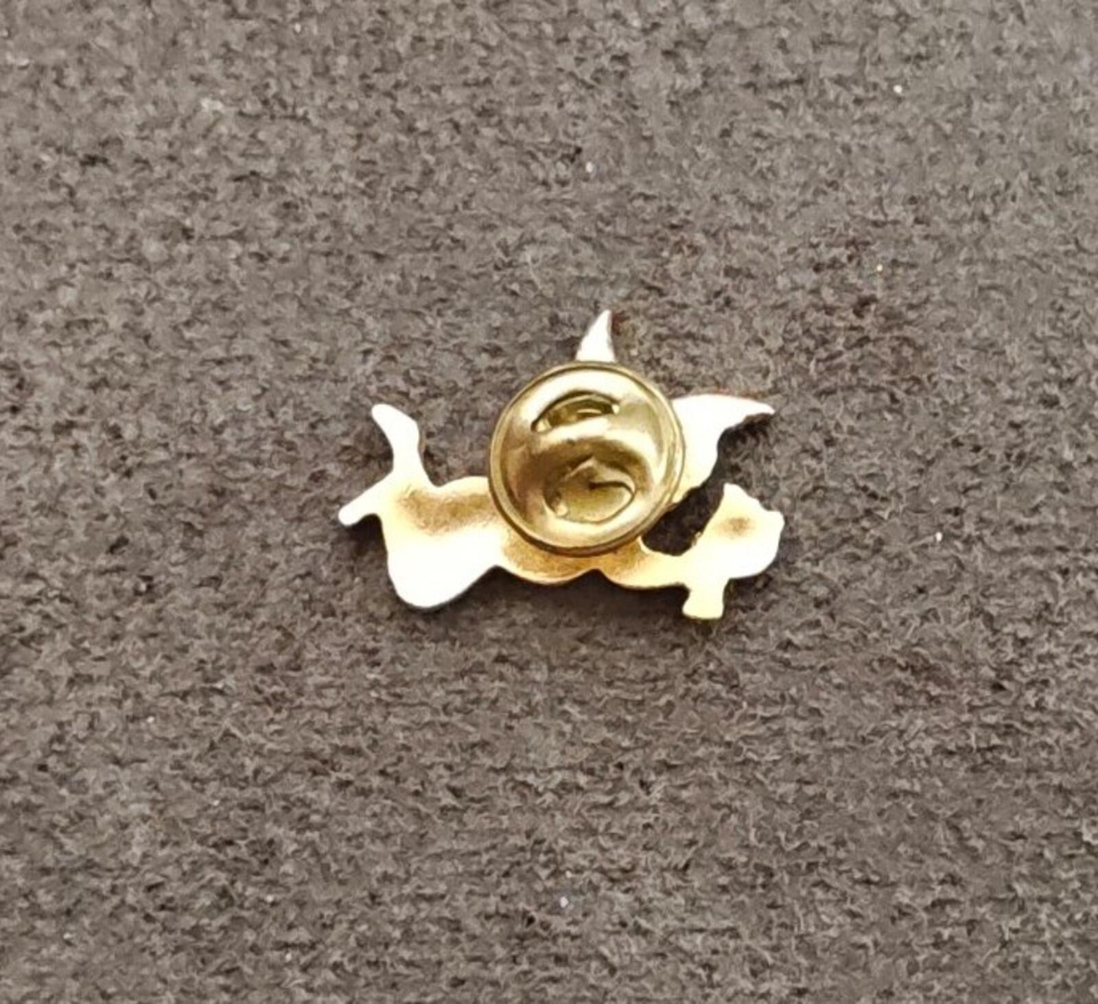 Gold tone angel brooch with spiral clasp, back view on fabric