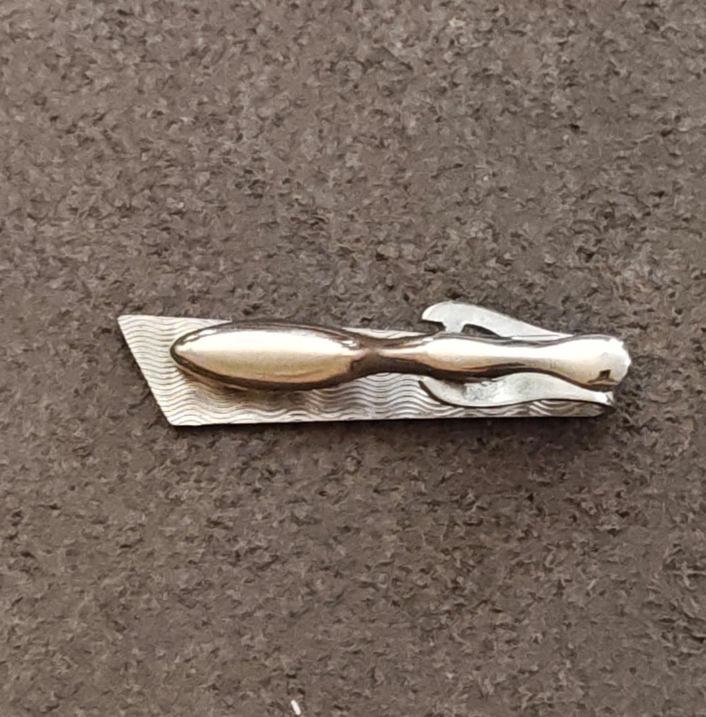 Silver-tone tie bar clip back view with wavy texture and clasp prongs