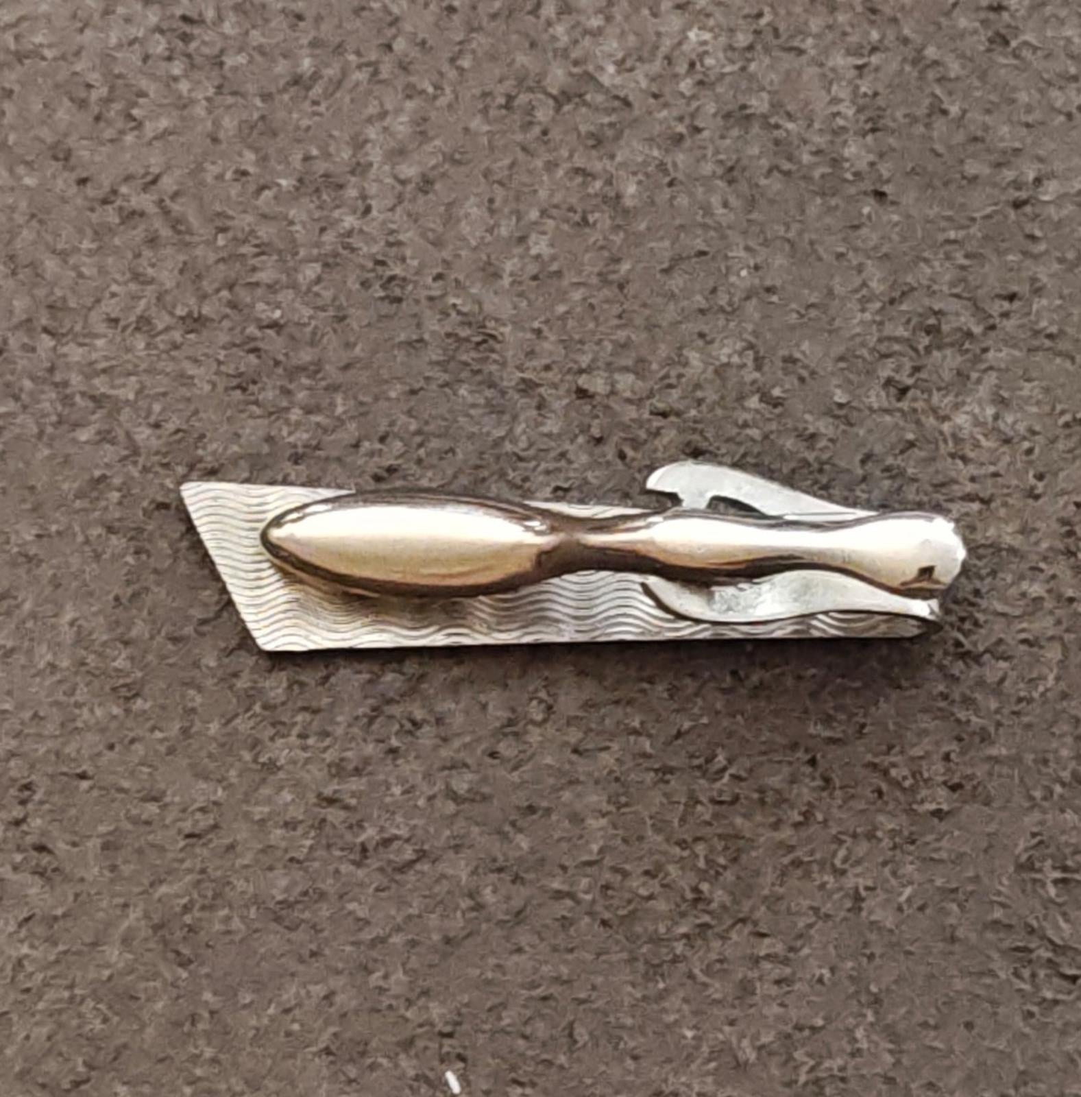 Silver-tone tie bar clip back view with wavy texture and clasp prongs