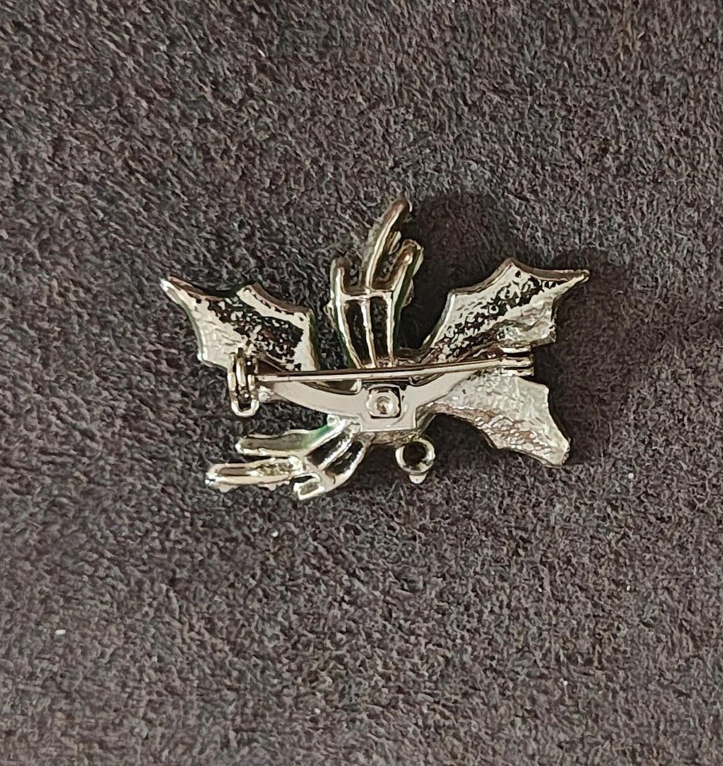 Holly enamel brooch pin back view with silver-toned metal and mounting loop