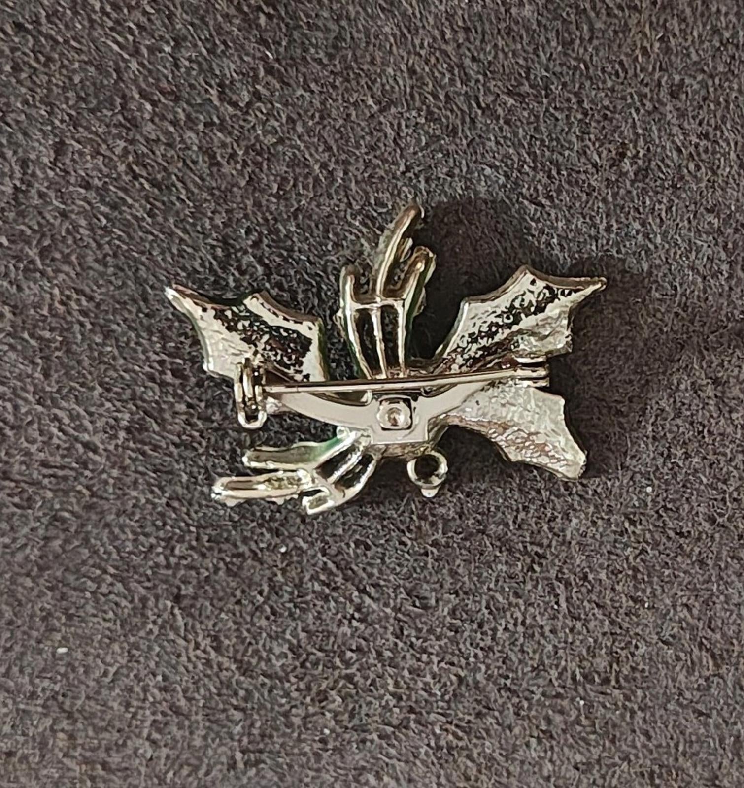 Holly enamel brooch pin back view with silver-toned metal and mounting loop