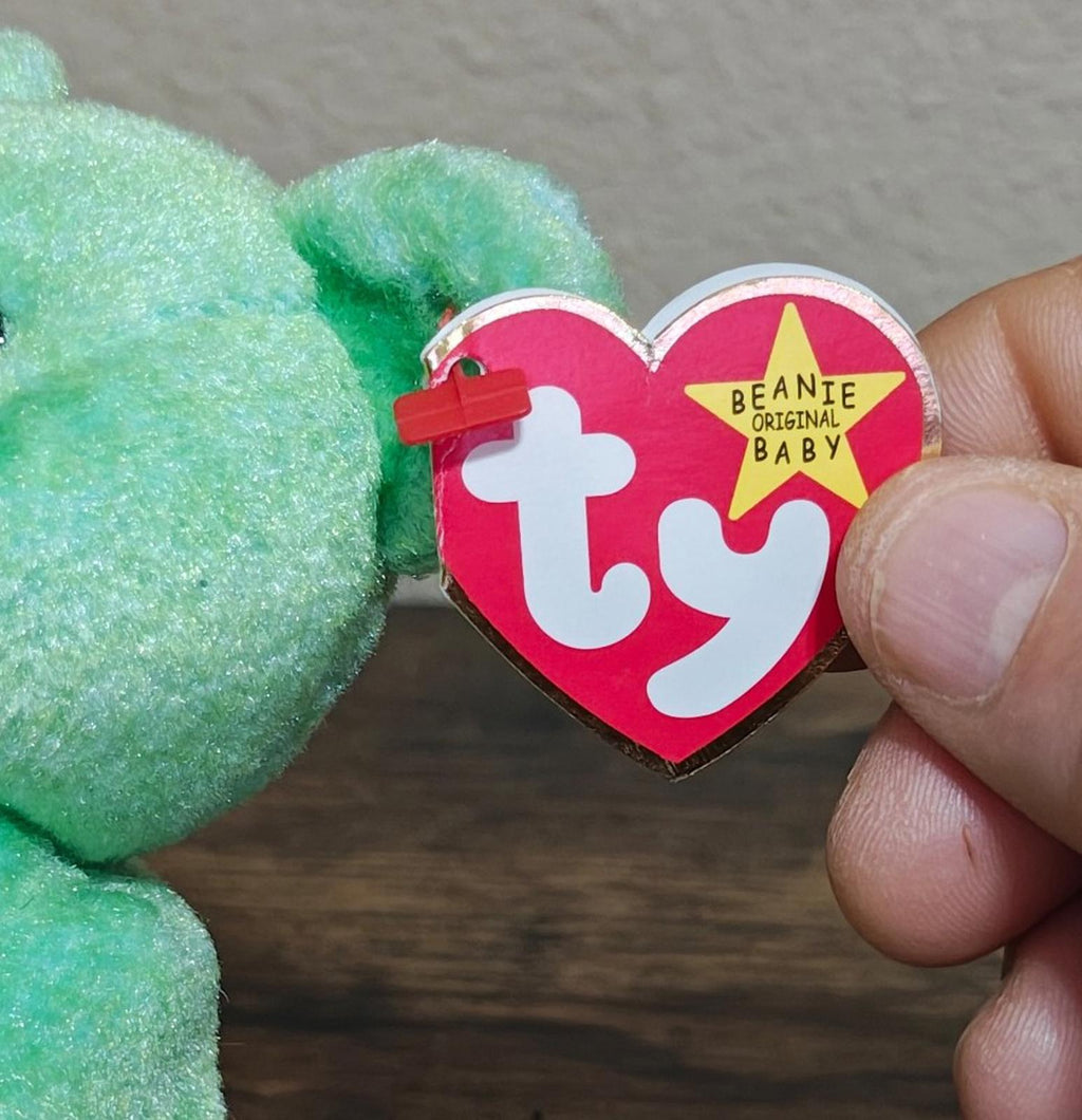 TY heart beanbag tag attached to green teddy bear plush.