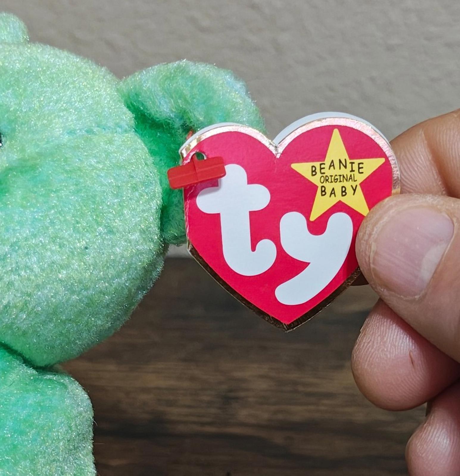 TY heart beanbag tag attached to green teddy bear plush.