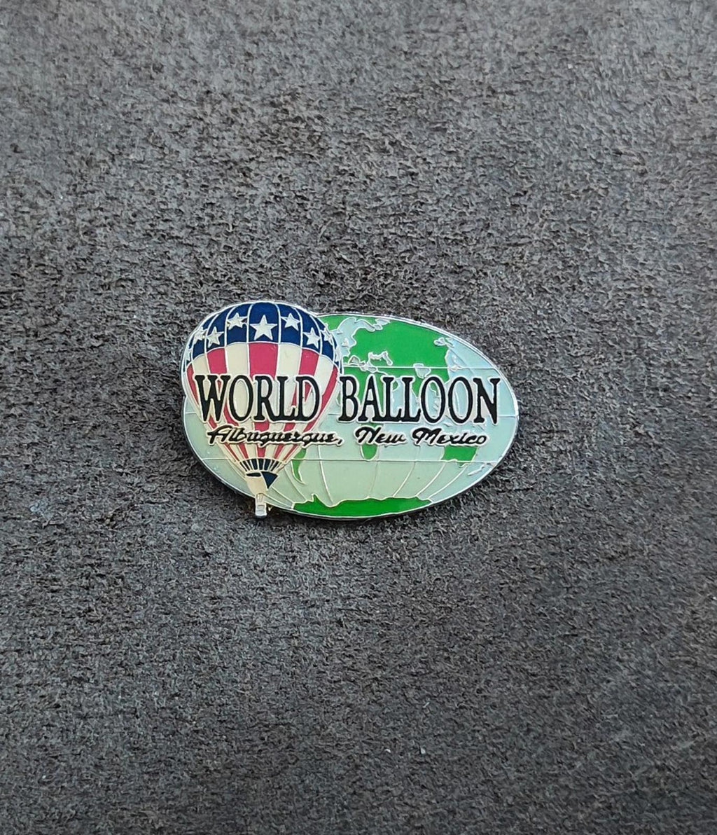 Silver-tone enamel lapel pin in oval shape with green balloon and blue star banner