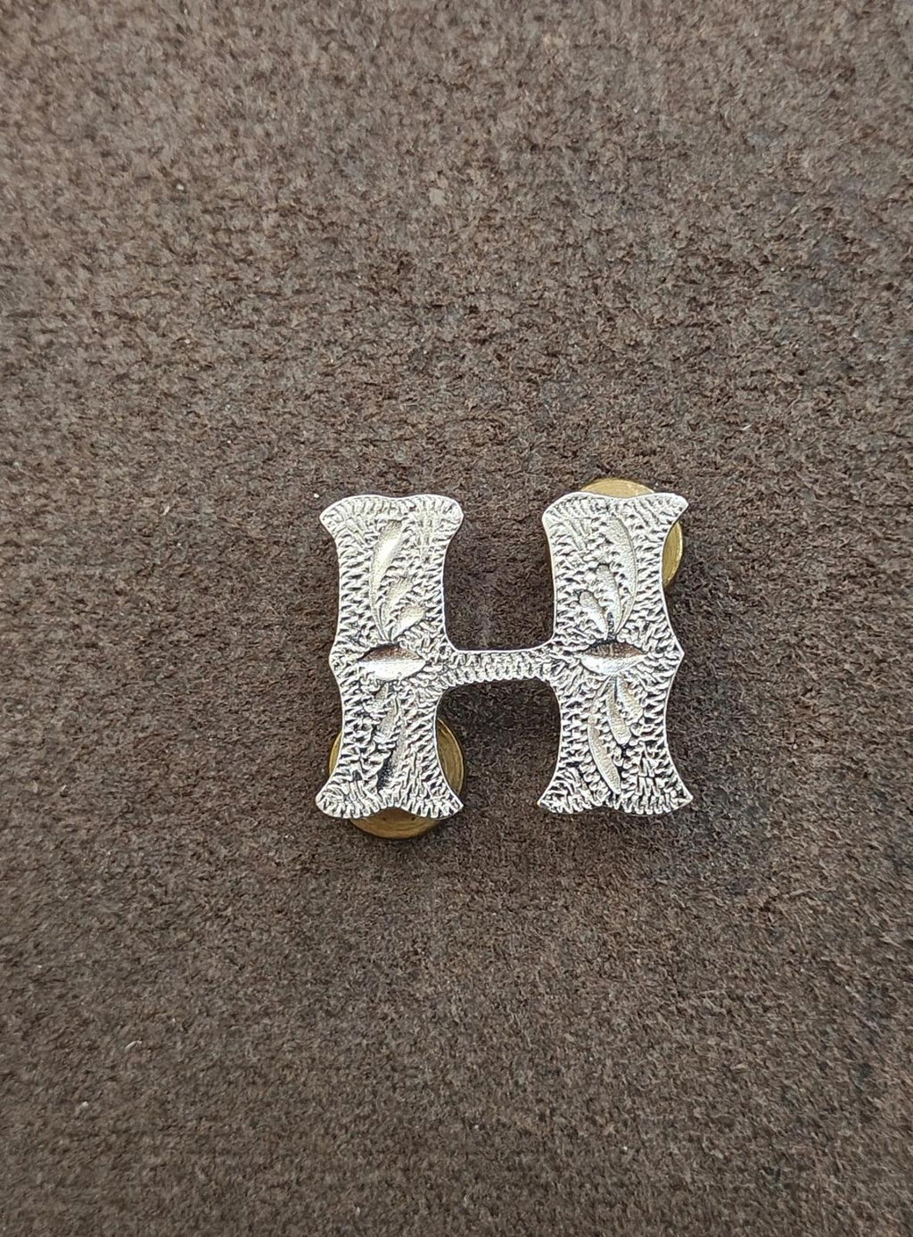 Silver-tone letter H screwback concho, centered view with textured pattern