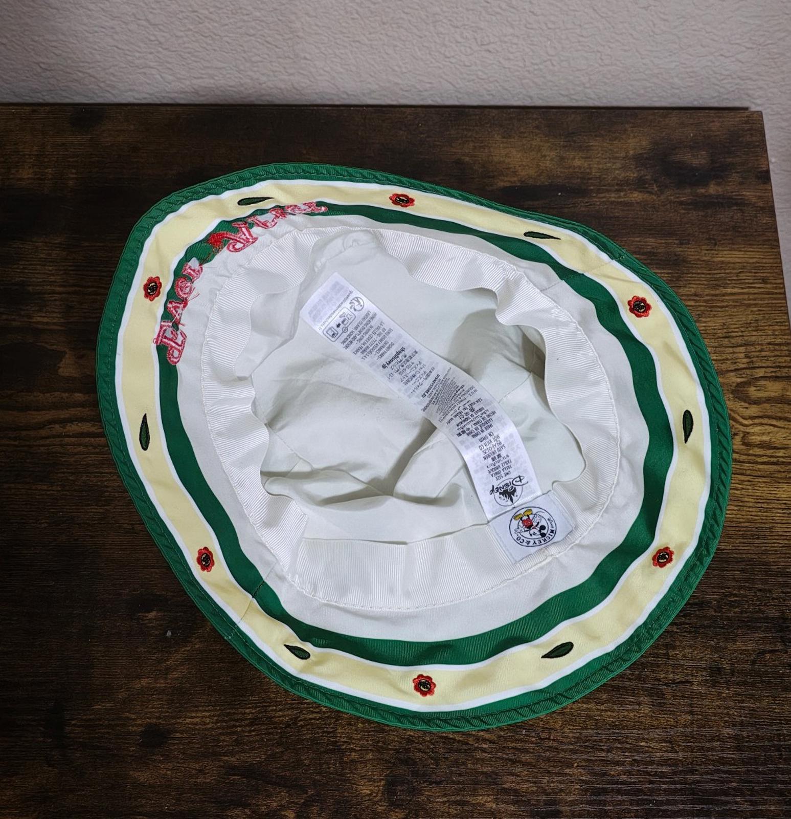 Inside view of cream bucket hat with green trim, white lining, fabric tag tucked inside
