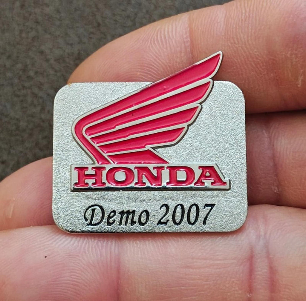 Silver-tone Honda Demo 2007 enamel pin close-up showing red wings and “Demo 2007”