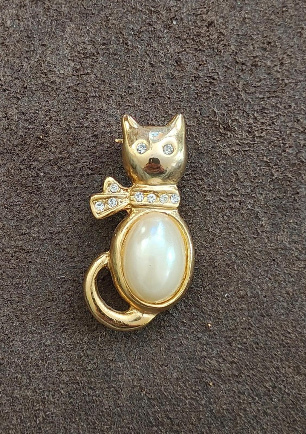 Gold-tone cat brooch with oval faux pearl body and rhinestone collar accents