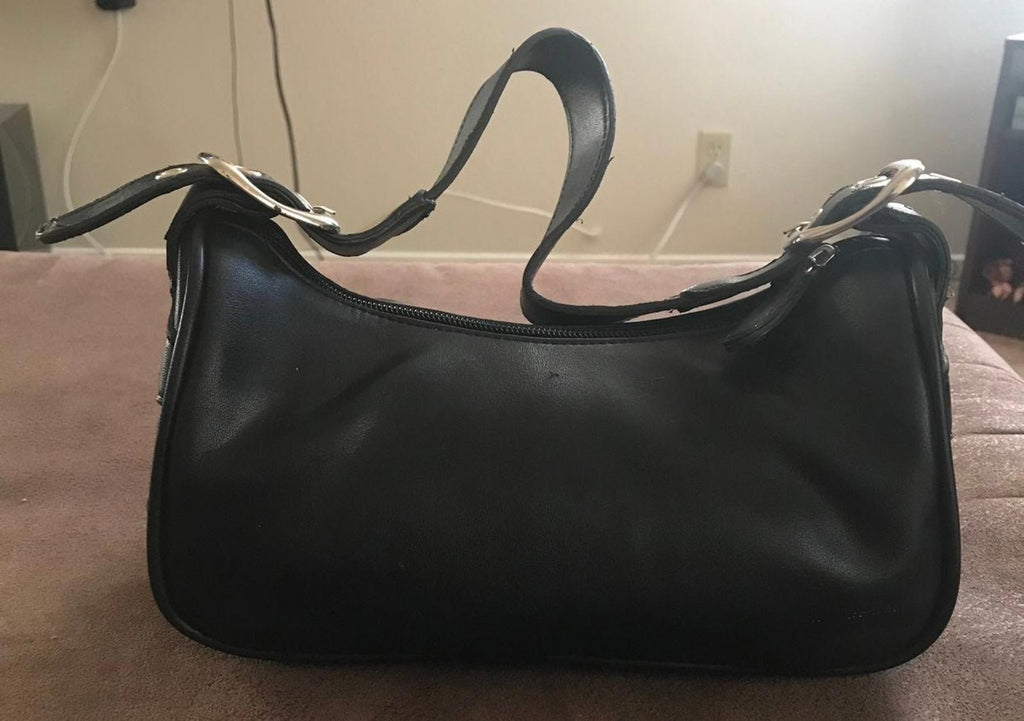 Black leather sling purse with top zipper and curved silhouette