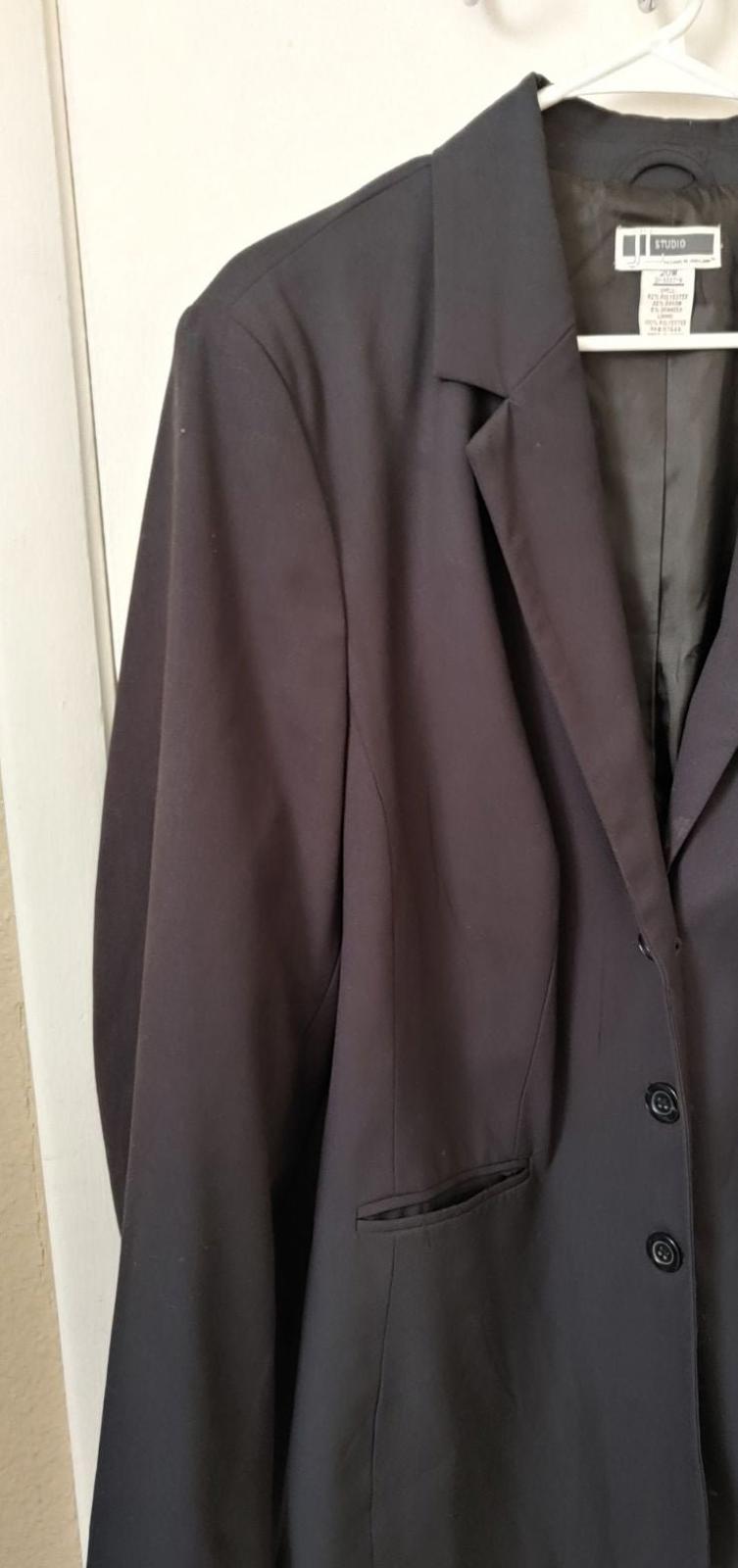Black blazer side view with button cuff and flap pocket detail.