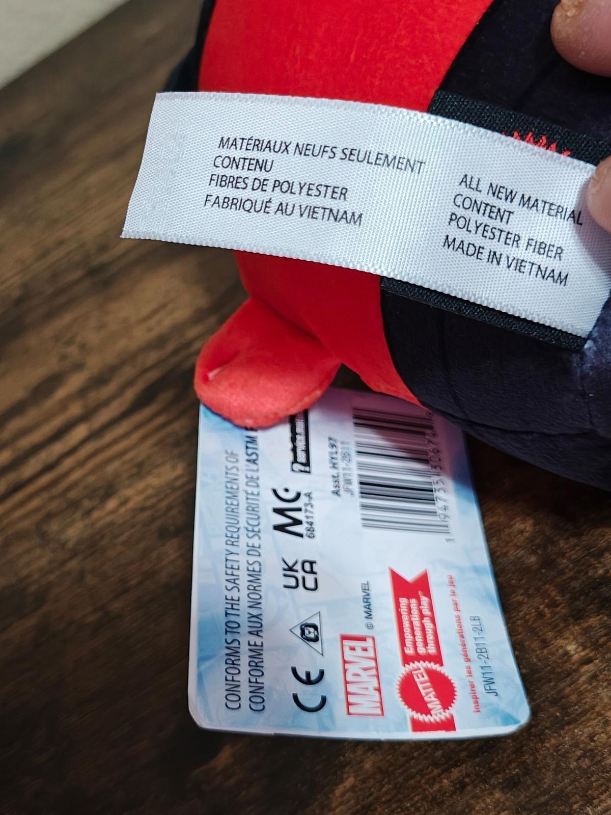 Close-up of plush material tag showing polyester fiber and made in Vietnam