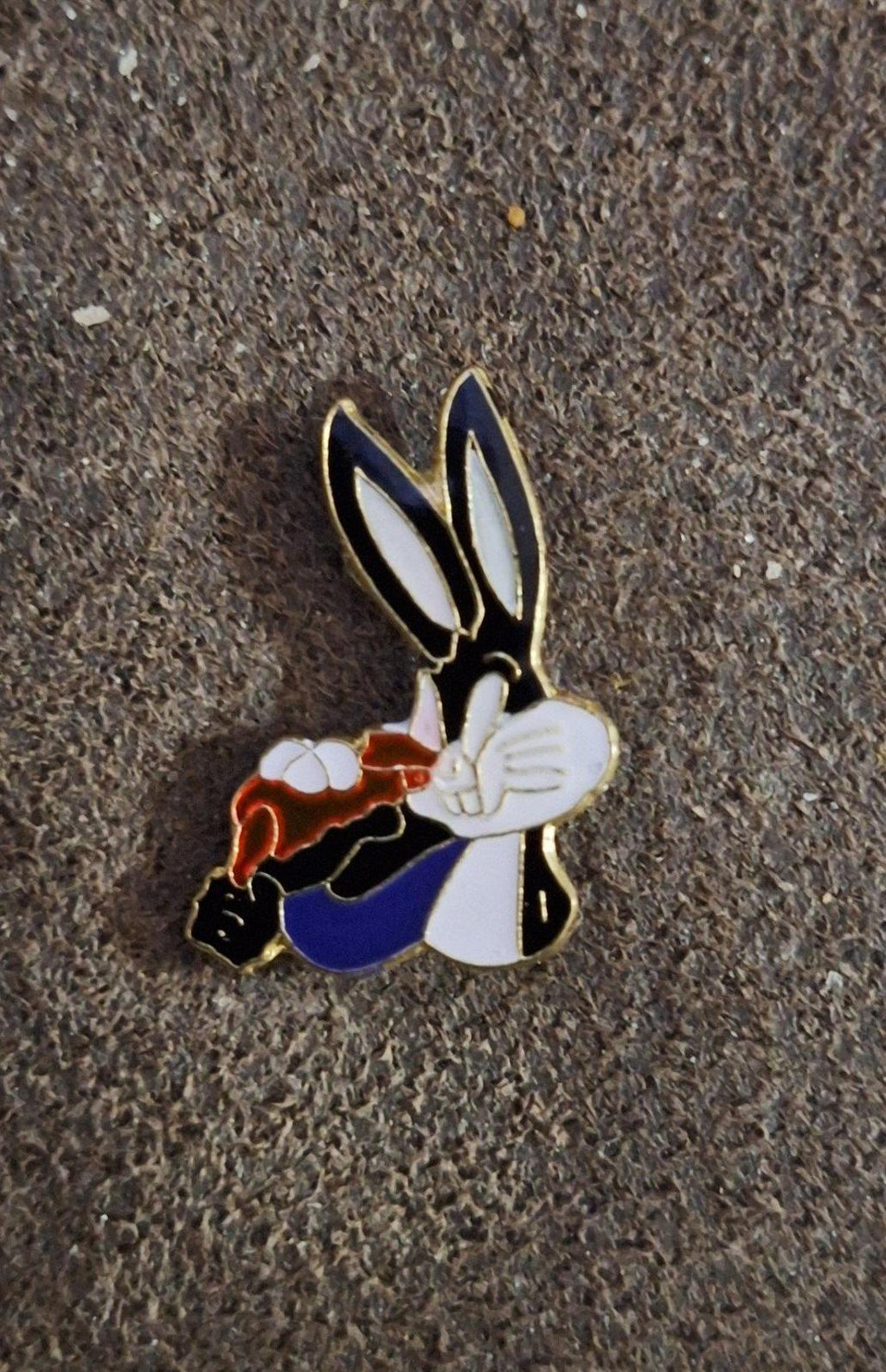 Enamel pin of Bugs Bunny holding carrot, colorful enamel character with gold outline