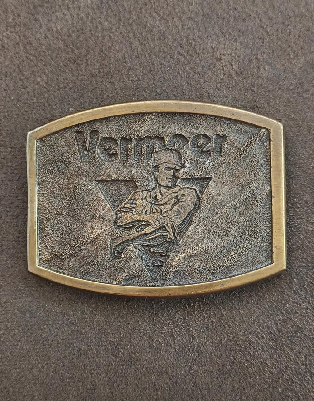 Solid brass belt buckle front detail showing engraved Vermer text and kneeling figure