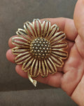 Gold tone textured sunflower brooch with bead-like center and raised petal rays