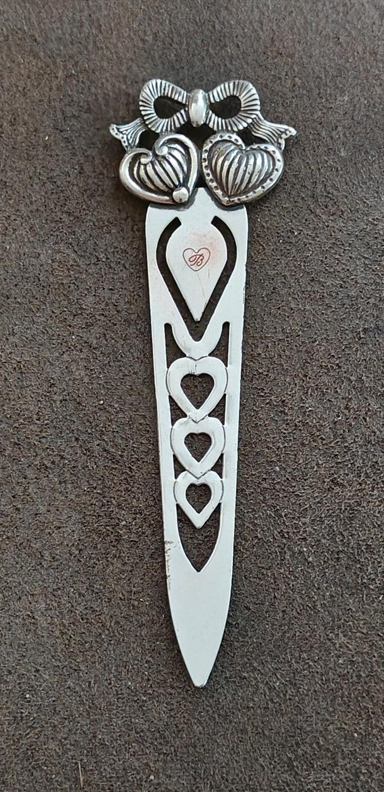 Silver plated letter opener bookmark with heart cutouts along the blade and pointed end