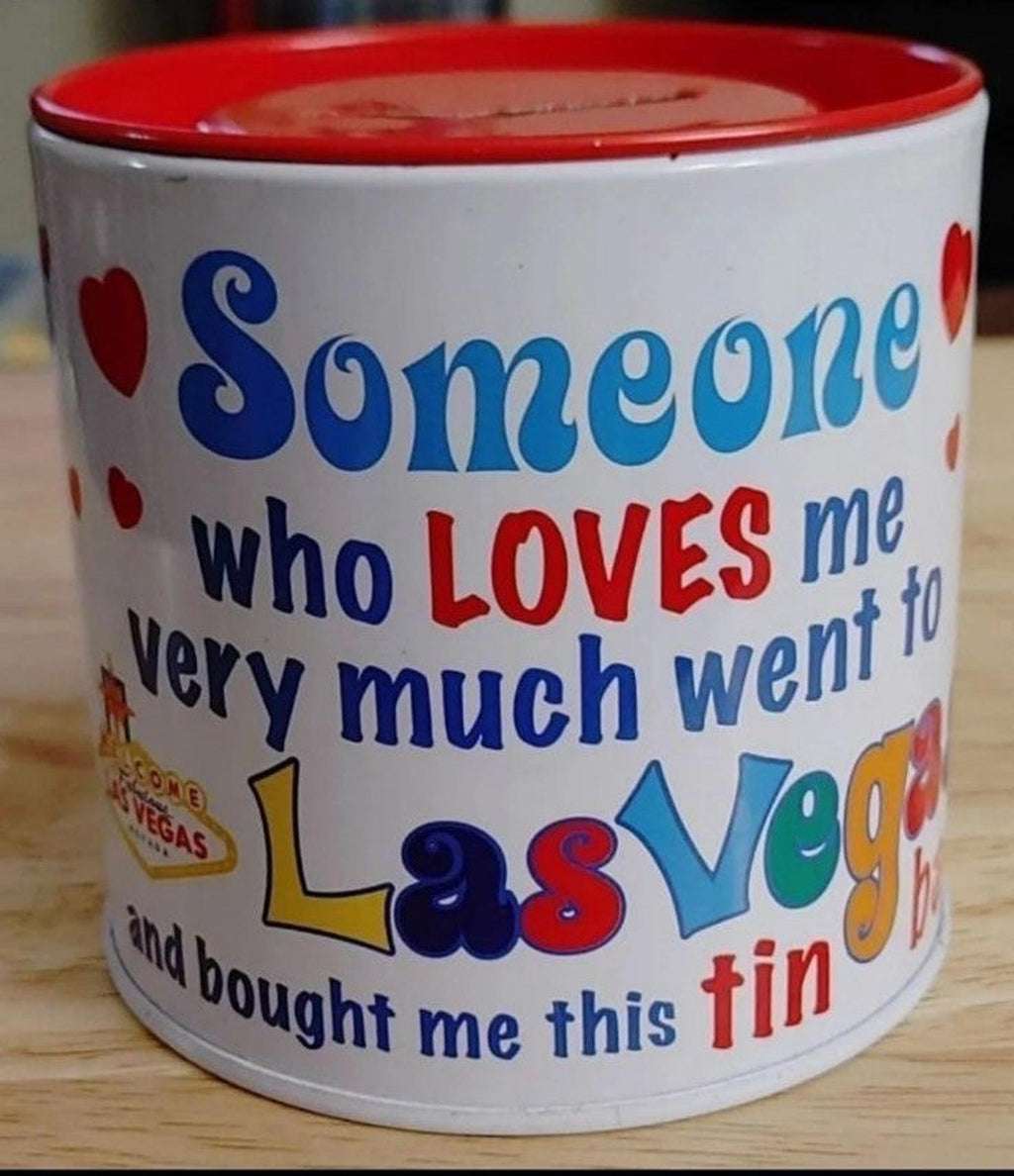 White tin bank with blue script and red lid, featuring Las Vegas text