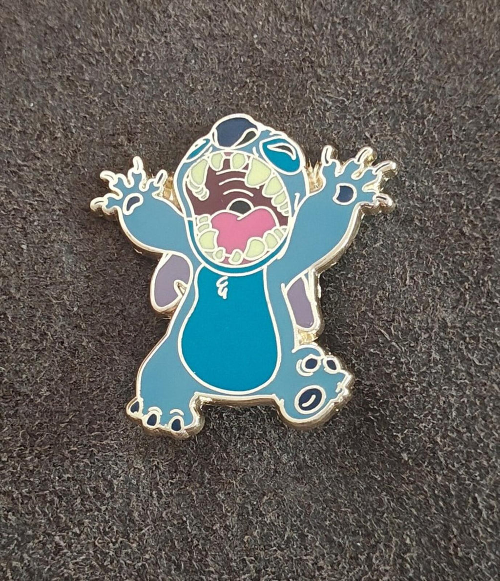 Blue Stitch enamel character pin on dark fabric, curled tail and gold-tone outline