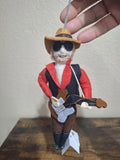 Felt and wool musician ornament with red jacket, black vest, hat, and guitar