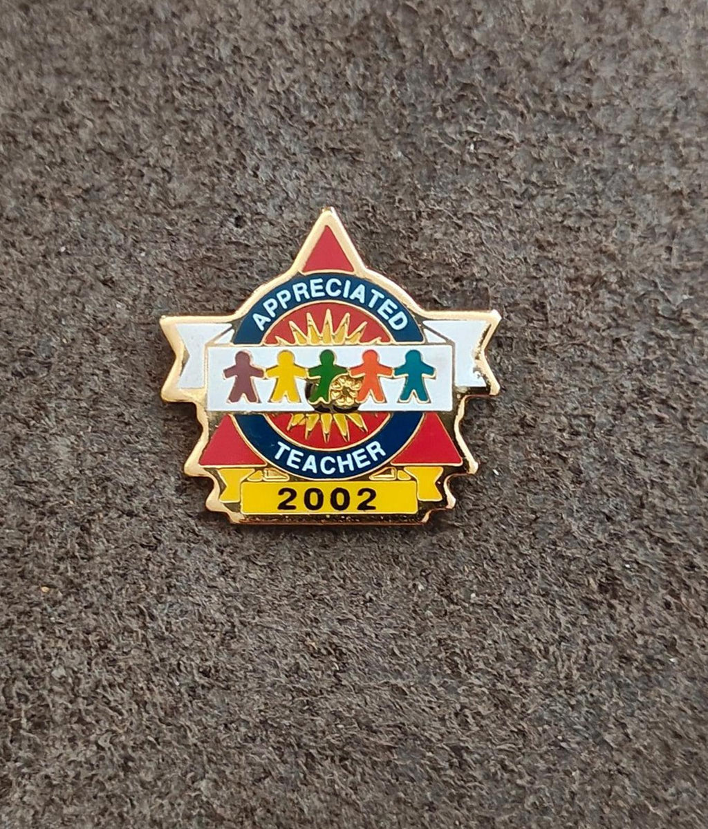 Teacher appreciation enamel pin: gold frame, blue badge, red ribbon, “2002”