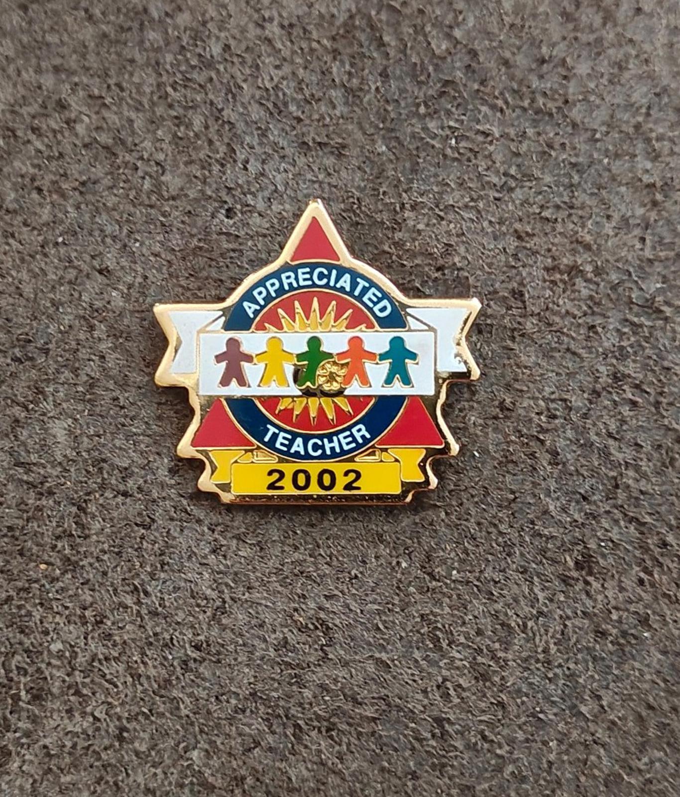 Teacher appreciation enamel pin: gold frame, blue badge, red ribbon, “2002”