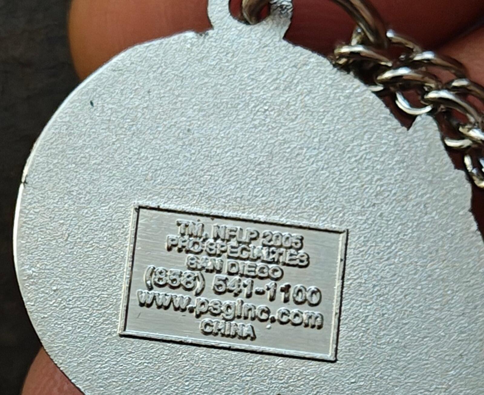 Metal pendant with engraved manufacturer label on a silver necklace chain