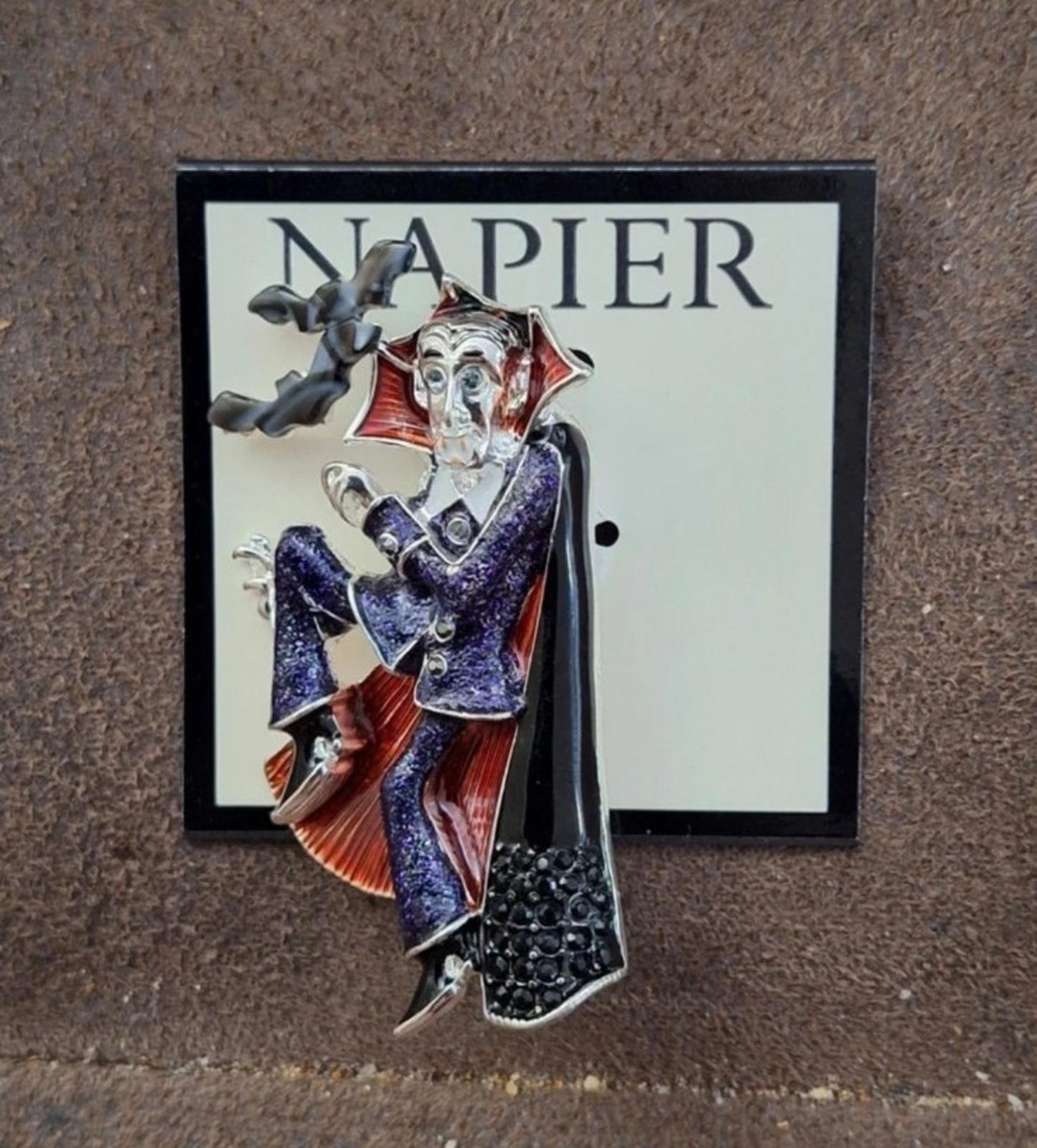 Vampire enamel pin with black cloak and red cape accents, detailed silver face