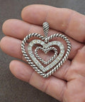Silver heart pendant with rope border, top loop, and rhinestone details