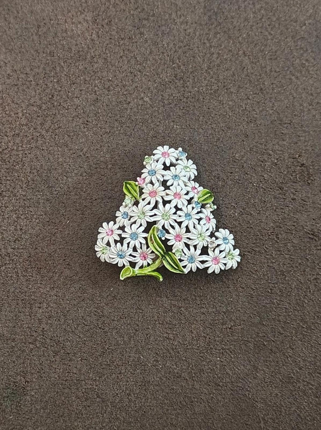 Gold-tone floral rhinestone brooch, white blossoms with blue and pink centers, green leaf accents