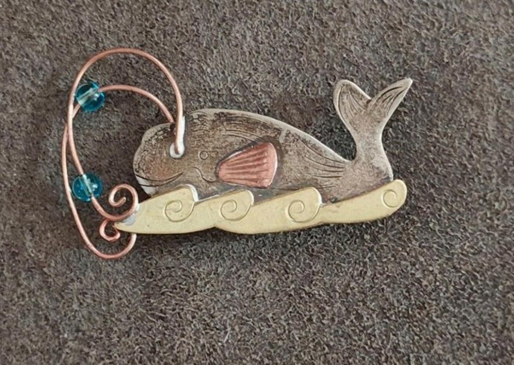 Gold-tone whale brooch pin with blue stones and orange fin, copper wire swirl and scrolls