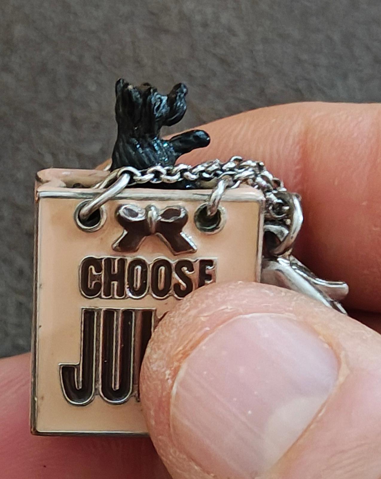 Juicy Couture bag charm square tag reading "CHOOSE JUICY" with black dog figure on top
