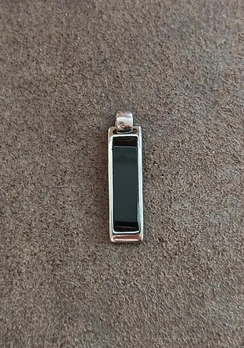 Silver-tone rectangular slide pendant with black edge framing; front inset window.